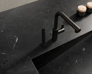 The custom sloped washbasin is created with premium porcelain, flowing directly from the countertop. 