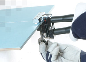 Montolit Reinforced Dual Splitting System being used by a man to nip off a piece of cut large format tile at an angle.